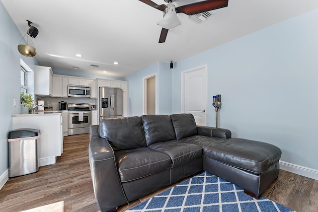 living room with ceiling fan and dark hardwood / wood-style flooring