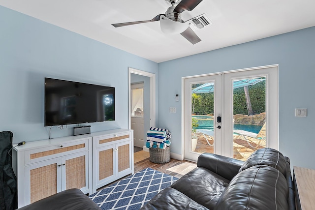 living room with light hardwood / wood-style flooring, ceiling fan, and french doors