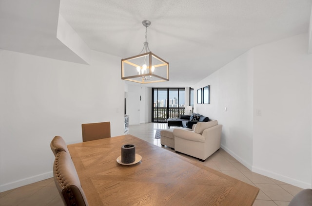 dining room with light tile patterned floors, baseboards, and a notable chandelier