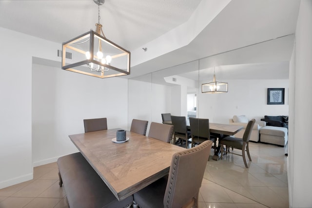 dining space with light tile patterned floors, baseboards, and an inviting chandelier