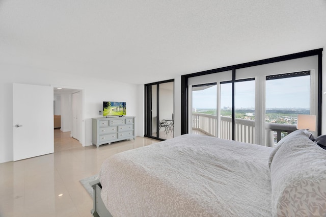 bedroom with light tile patterned floors, access to outside, a textured ceiling, and floor to ceiling windows