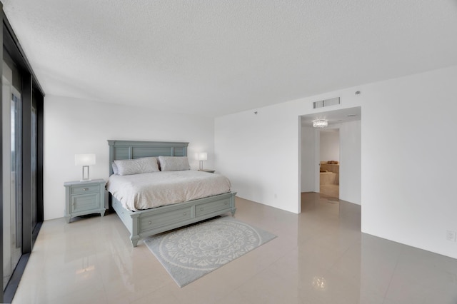 bedroom with light tile patterned floors, visible vents, and a textured ceiling