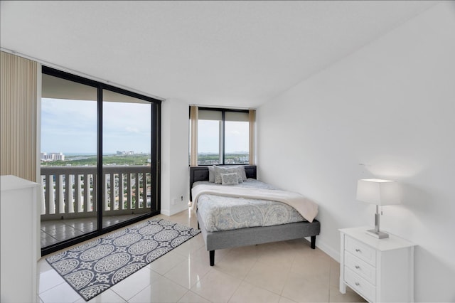 bedroom featuring light tile patterned floors, access to outside, expansive windows, and baseboards