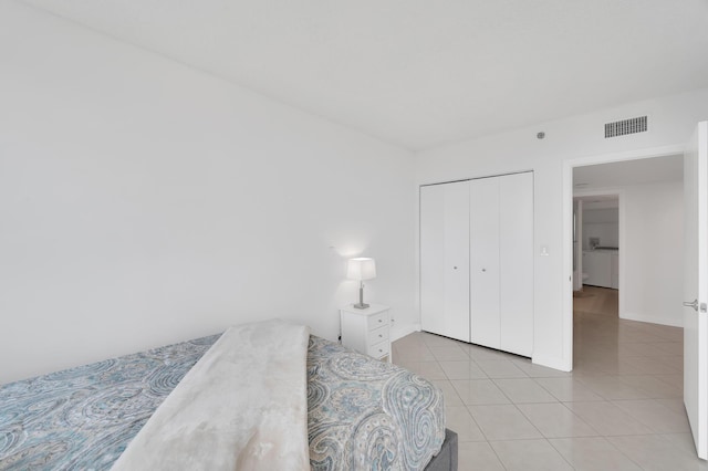 bedroom with a closet, visible vents, and light tile patterned floors