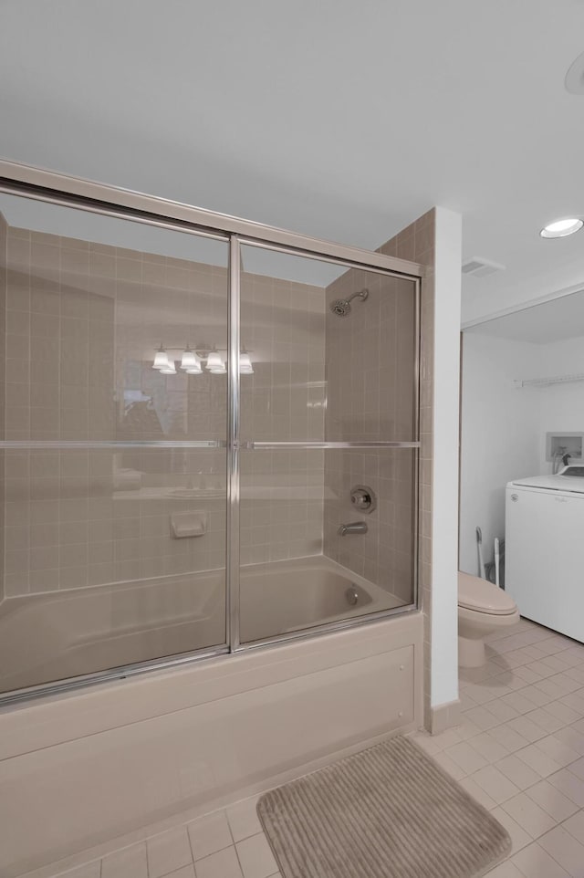 full bath featuring toilet, washer / dryer, combined bath / shower with glass door, and tile patterned floors