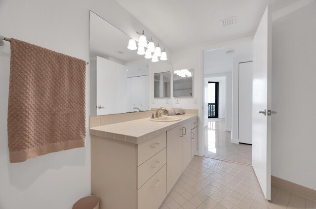 bathroom featuring tile patterned flooring, visible vents, vanity, and baseboards