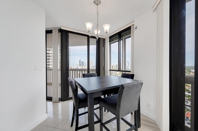 dining space with light tile patterned floors, an inviting chandelier, baseboards, and a city view