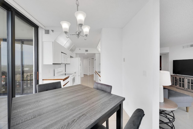 dining area featuring an inviting chandelier, light tile patterned floors, and visible vents