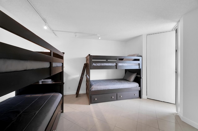 bedroom featuring baseboards and a textured ceiling