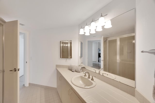 bathroom with a stall shower, tile patterned floors, baseboards, and vanity