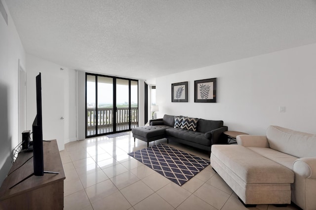 living room with floor to ceiling windows, a textured ceiling, and light tile patterned floors