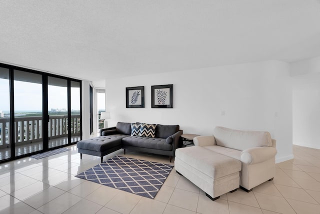 living area featuring light tile patterned floors, floor to ceiling windows, and a textured ceiling