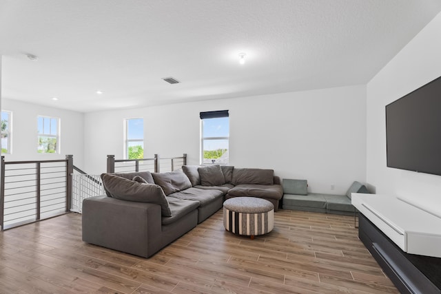 living area featuring plenty of natural light, wood finished floors, and visible vents