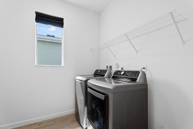 laundry area with laundry area, light wood-style flooring, baseboards, and separate washer and dryer