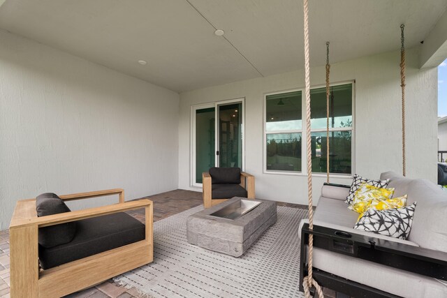 view of patio with an outdoor living space with a fire pit