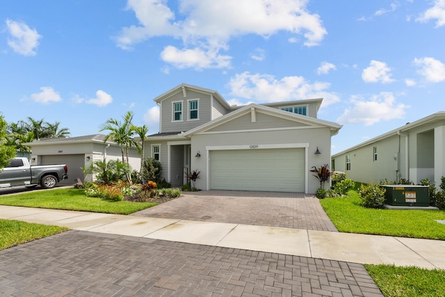 traditional-style house featuring a garage, central AC unit, a front lawn, and decorative driveway