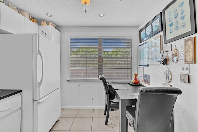 tiled dining room with a textured ceiling