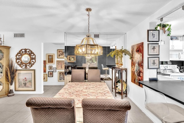 dining area with a textured ceiling, light tile patterned floors, and a chandelier