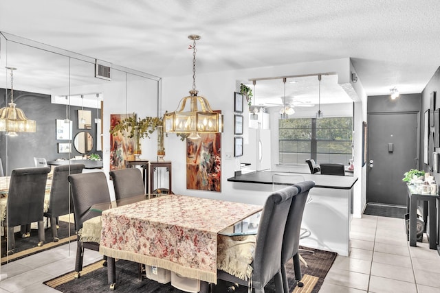 tiled dining area with ceiling fan with notable chandelier and a textured ceiling