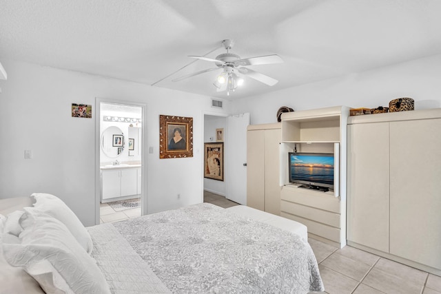 tiled bedroom featuring ceiling fan and ensuite bathroom