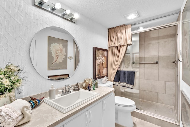 bathroom featuring tile patterned floors, toilet, vanity, tiled shower, and a textured ceiling