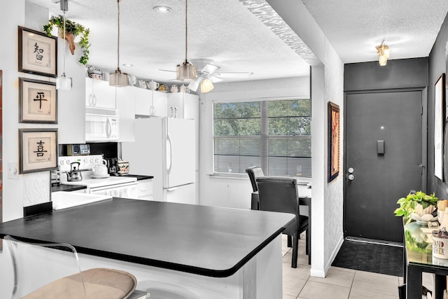 kitchen featuring white appliances, white cabinetry, kitchen peninsula, ceiling fan, and a textured ceiling