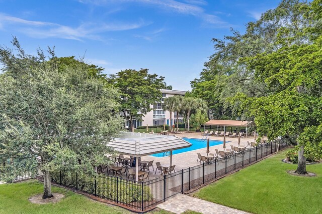 view of pool featuring a lawn and a patio