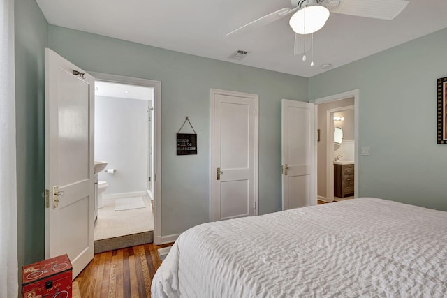 bedroom with ceiling fan, ensuite bathroom, and dark hardwood / wood-style flooring