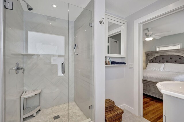 bathroom with a shower with shower door, ceiling fan, and wood-type flooring