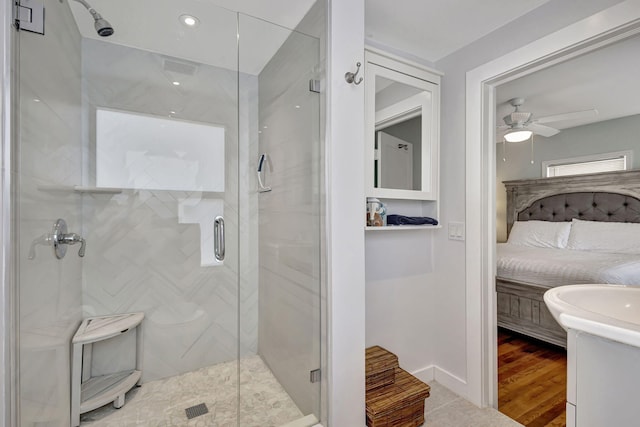 bathroom with a shower with door, vanity, and ceiling fan