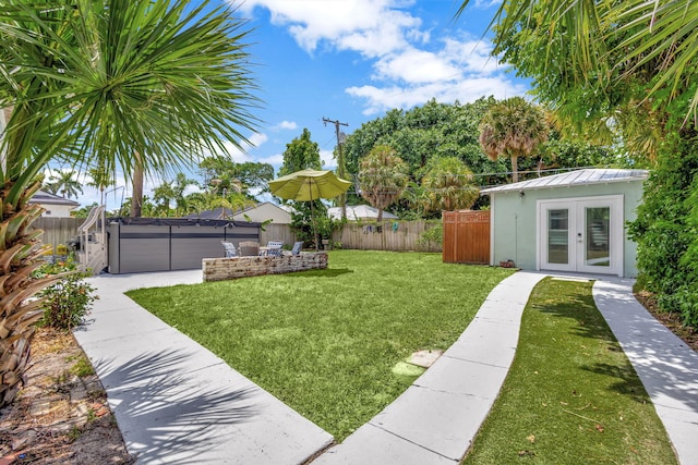 view of yard featuring french doors, a hot tub, an outdoor structure, and a patio