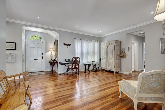 entryway with ornamental molding and light wood-type flooring