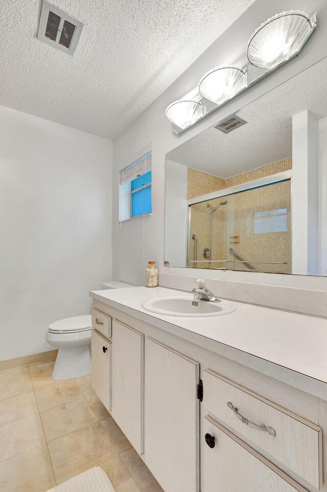 bathroom featuring walk in shower, a textured ceiling, vanity, and toilet