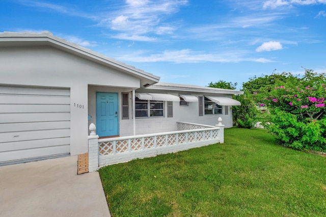 doorway to property featuring a garage and a lawn