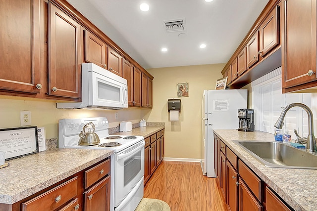 kitchen featuring light hardwood / wood-style flooring, white appliances, and sink