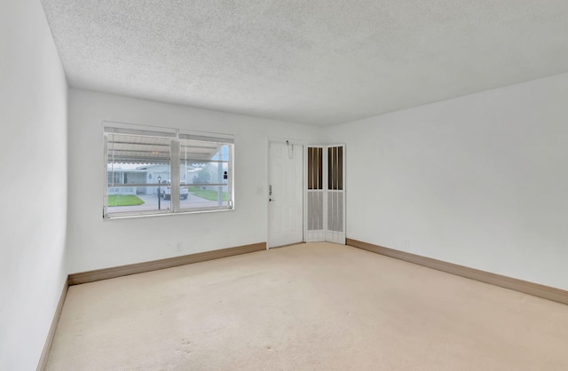 carpeted spare room with a textured ceiling