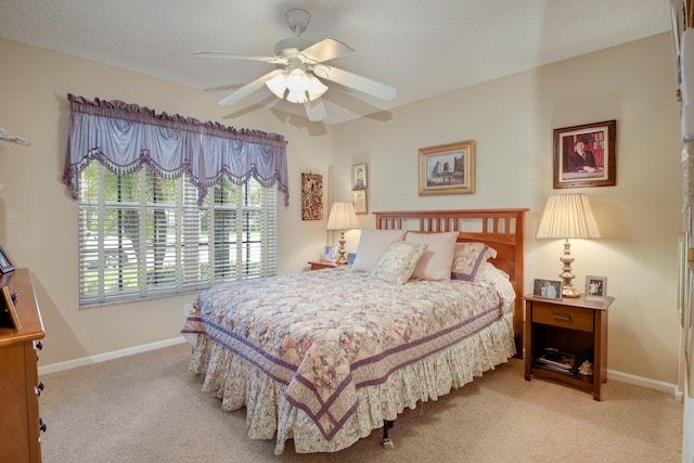 carpeted bedroom with ceiling fan and a textured ceiling