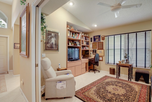 tiled office space with ceiling fan, a textured ceiling, and vaulted ceiling