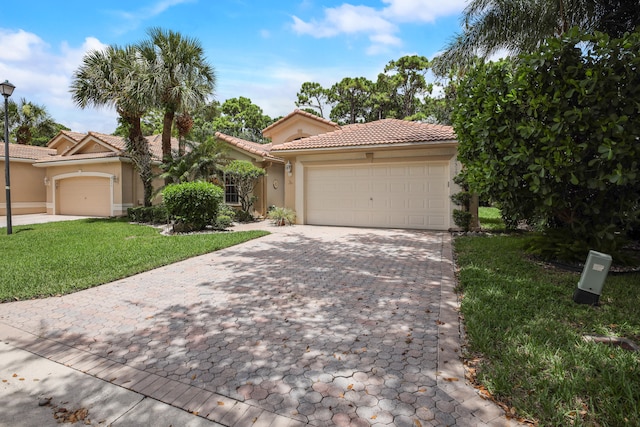 mediterranean / spanish home featuring a garage and a front lawn