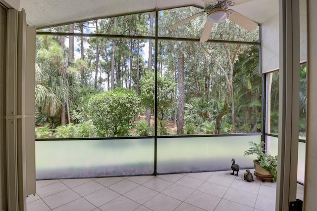 unfurnished sunroom with ceiling fan and vaulted ceiling