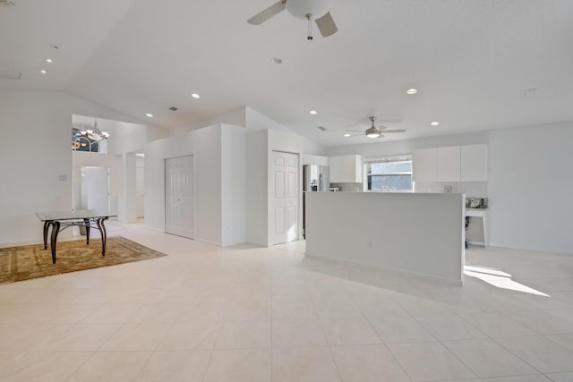 tiled living room featuring ceiling fan with notable chandelier and lofted ceiling