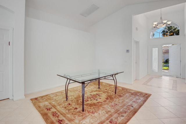 tiled entryway with high vaulted ceiling and an inviting chandelier