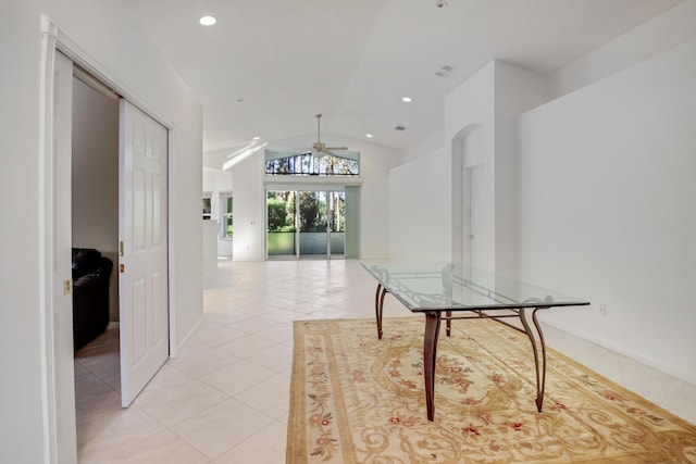 corridor with light tile patterned floors and lofted ceiling