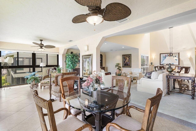 tiled dining space with ceiling fan and a textured ceiling