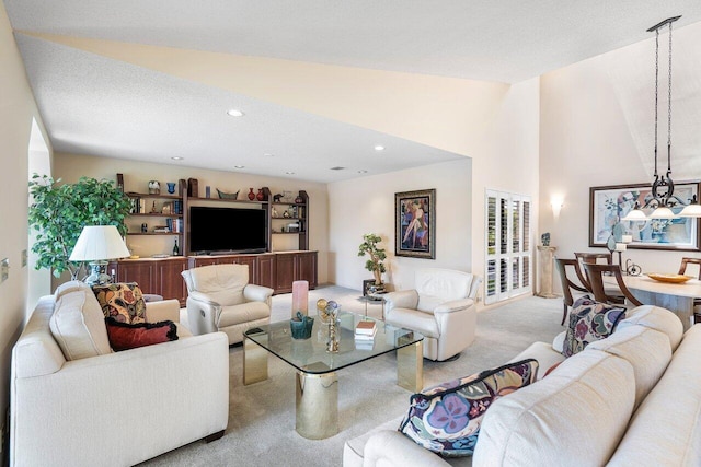 carpeted living room with a textured ceiling and lofted ceiling