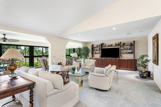 living room featuring a textured ceiling, ceiling fan, lofted ceiling, and light colored carpet