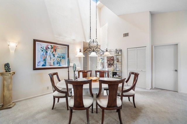 dining space with light colored carpet and a towering ceiling