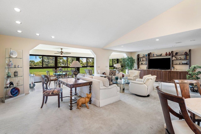 carpeted living room with ceiling fan and lofted ceiling