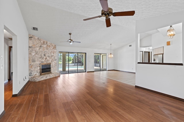 unfurnished living room featuring a textured ceiling, vaulted ceiling, hardwood / wood-style flooring, and ceiling fan