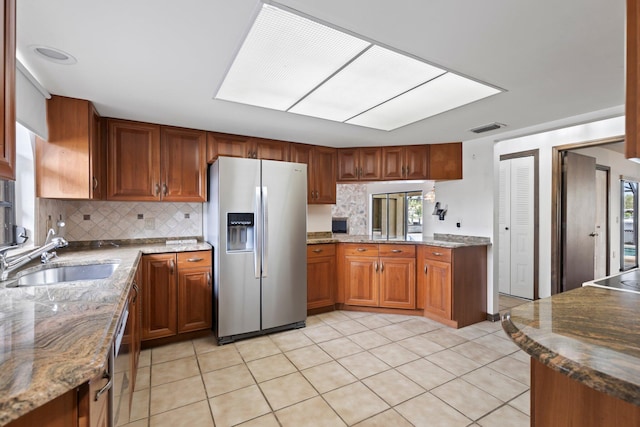 kitchen with light tile patterned floors, a healthy amount of sunlight, sink, and stainless steel refrigerator with ice dispenser